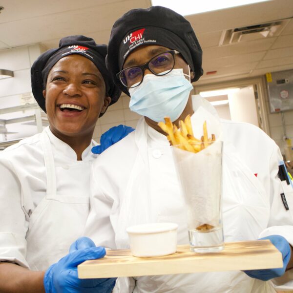 two woman pose with fries